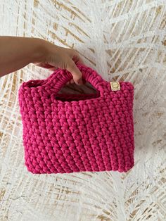 This adorable pink crochet mini handbag is perfect for the modern and trendy woman in your life. This small bag is not only fashionable but also functional, making it the ideal accessory for any outfit. It would make a lovely Christmas gift for her, adding a touch of charm to her wardrobe. Handcrafted with care, this purse is a unique and stylish addition to any collection. The bag is made of cotton cord having OEKOTEX Standard 100 Certificate. The small handbag is available in many colors.  In Pink Square Crochet Bag For Gift, Pink Rectangular Crochet Bag For Shopping, Rectangular Pink Crochet Bag For Shopping, Trendy Handheld Crochet Bag For Gift, Trendy Handheld Crochet Bag As Gift, Pink Hand Knitted Bags For Gifts, Rectangular Pink Crochet Shopping Bag, Hand Knitted Pink Bags For Gifts, Pink Crochet Bag For Gift