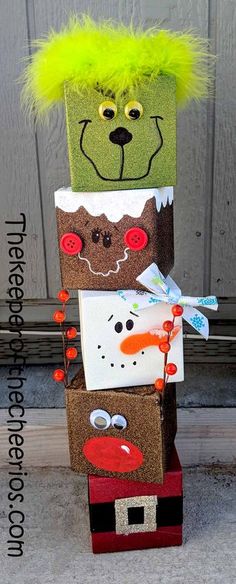 a stack of cardboard boxes with faces and hair on them sitting in front of a door