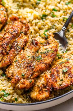 chicken and rice in a skillet with a serving spoon on the side, ready to be eaten