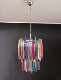 a multicolored chandelier hanging from a ceiling in a room with black walls