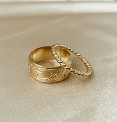 One of our most-loved rings ~ Marigold is a cigar band ring with a vintage floral design. Add this charming piece to your collection to stack or make a statement. * Customers report that this ring fits tight. Recommended to order 1/2 size up from your normal ring size if you prefer a more loose fit or if your fingers tend to swell. ﻿Band width: 8 mm // Band thickness: 0.5 mm Modeled with our bold rope ring Handmade to order in high-quality 14k gold fill to withstand daily wear time after time. Vintage Gold Stackable Rings, Vintage Gold Band, Thick Band Engagement Ring, Custom Gold Rings, Thick Gold Ring, Rope Ring, Vintage Gold Rings, Vintage Floral Design, Time After Time