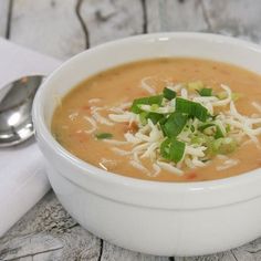 a white bowl filled with soup on top of a wooden table