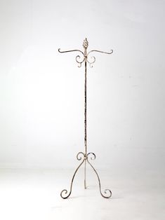 a metal coat rack with two hooks on each side and an iron rod at the top