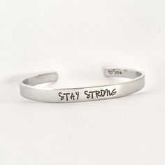 STAY STRONG This inspirational hand stamped cuff bracelet makes the perfect gift to give or treat for yourself. The cuff is 1/4 inch by 6 inches and is bent to fit most wrists. My items are hand stamped by me, making them a unique gift. Each letter is stamped individually and may not line up exactly adding to the charm and uniqueness of the gift. Visit my shop to view all of my other items by clicking here: https://www.etsy.com/shop/GemsbyJohnna Please see my shop header for current production t Personalized Inspirational Cuff Bracelet For Everyday, Everyday Inspirational Personalized Cuff Bracelet, Adjustable Personalized Cuff Bracelet For Everyday, Inspirational Stamped Adjustable Cuff Bracelet, Personalized Everyday Meaningful Cuff Bracelet, Everyday Personalized Meaningful Cuff Bracelet, Inspirational Adjustable Stamped Cuff Bracelet, Inspirational Adjustable Cuff Bracelet For Personalized Gift, Hand Stamped Bangle Cuff Bracelet