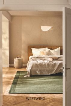 an open door leading to a bedroom with a bed and green rug on the floor