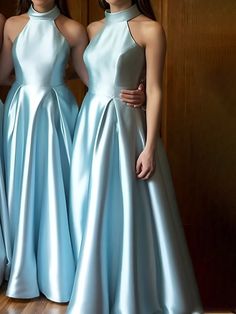 three women in long blue dresses standing next to each other on a hard wood floor