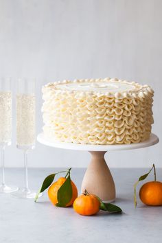 a cake with white icing and two glasses of champagne