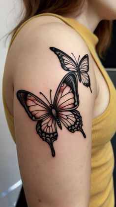 a woman's arm with a butterfly tattoo on the left side of her shoulder