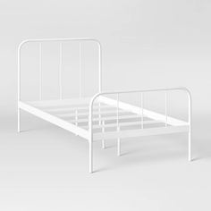 a white metal bed frame with no headboard and foot board is shown in front of a plain background