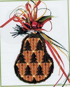 a christmas ornament hanging from a red ribbon on a white card with green trim