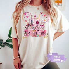 a woman standing in front of a white wall wearing a t - shirt that says disney