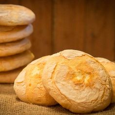 a pile of round bread sitting on top of a table next to a stack of cookies