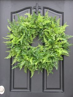 a fake wreath on the front door of a house that is advertised for $ 150 in stock