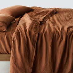 a bed with brown sheets and pillows on it