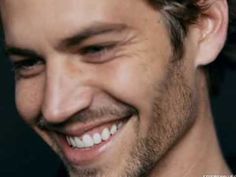 a close up of a person smiling and wearing a black shirt