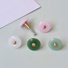 three different colored knobs on top of a white table next to a piece of paper