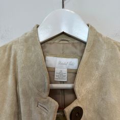 New with tags, vintage Marshall Field's Suede Leather Jacket Beige Taupe Button Down. Button down jacket blazer with two front pockets. Mandarin collar style. Light brown tan beige color suede genuine leather. Fully lined. Item has a few marks on the back of the jacket, as shown in photos. Women's size 14 100% genuine leather Approximate measurements with the garment laying flat: Pit to pit: about 20 inches Length: about 26 inches Shoulder seam to the end of the sleeve: about 24.5 inches Shoulde Vintage Beige Outerwear With Snap Buttons, Beige Leather Jacket With Button Closure For Work, Beige Leather Jacket With Button Closure For Fall, Vintage Leather Jacket With Buttons For Spring, Spring Beige Leather Jacket With Button Closure, Beige Leather Jacket With Button Closure For Spring, Vintage Beige Blazer With Button Closure, Beige Vintage Blazer With Button Closure, Beige Formal Outerwear With Snap Buttons