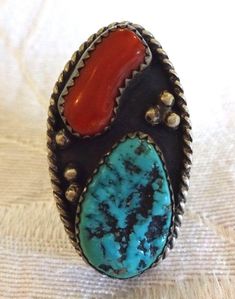 "VINTAGE NAVAJO RING DESCRIPTION: This ring features an exquisite cabochon old Kingman turquoise, anchored with a stunning specimen of old red Mediterranean branch coral. Applied raindrops punctuate the dark patina background. This impressive ring will be a treasured addition to your collection of fine vintage Native American jewelry. MEASUREMENTS: Ring face measures 1 1/4\" x 3/4\" Turquoise cabochon measures 17mm x 11mm RING SIZE: 7 1/4 WEIGHT: 8.0 grams SIGNED: WL, for Willie Long (Navajo) ST Southwestern Multi-stone Oval Turquoise Ring, Southwestern Oval Turquoise Multi-stone Ring, Antique Oval Turquoise Ring, Collectible Multi-stone Turquoise Oval Ring, Unique Oval Multi-stone Turquoise Ring, Antique Untreated Turquoise Jewelry, Vintage Multi-stone Oval Cabochon Rings, Antique Turquoise Gemstone Ring, Southwestern Style Cabochon Rings, Collectible