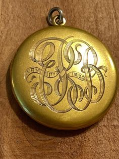 This lovely old locket is part of my antique locket collection which I am beginning to put up for sale.  It is a  round gold locket that was acid tested to be 9 or 10 k solid yellow gold.  It is beautifully hand engraved with elaborately entwined letters which I cannot make out. Perhapse you can!  It is also engraved with a date, "Nov 11th 1902". The  locket snaps shut tightly and opens with the aid of two little divits on the edge for your finger nails. Using a knife blade would scratch up and mar the gold.  The hinge is also tight and in perfect, vintage condition.  Judging from its construction, and the engraving, I'd say this locket was made about  1900,  making it about 125 yers old.  It  is simple and elegant, with it's round shape and mellow satin finish with absolutely no dents, ju Antique Gold Locket Necklace Stamped 14k, Antique Medallion Locket Necklace Stamped 14k, Vintage 14k Gold Locket Necklace Stamped 14k, Victorian Round Locket Necklace Stamped 14k, Antique Jewelry With Engraving Option For Anniversary, Antique Commemorative Round Jewelry, Classic Vintage Charm Locket Necklace Collectible, Commemorative Locket Jewelry, Vintage 14k Gold Locket Necklace