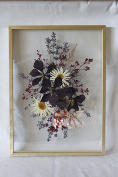 an arrangement of flowers in a wooden frame