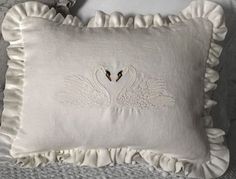 a white pillow with two black birds on it and ruffles around the edges