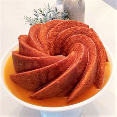 a white bowl filled with sliced fruit on top of a table next to a vase