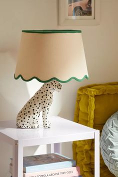 a white table with a lamp and a cheetah figurine on it