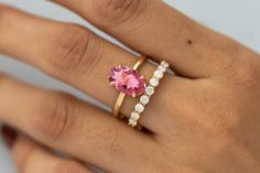 a woman's hand with a pink ring on it