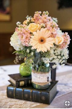 a vase filled with flowers sitting on top of two books