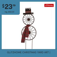 a christmas yard art display with a windmill and plaid scarf on it's head