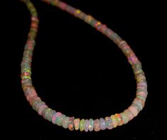 a multicolored glass beaded necklace on a black background