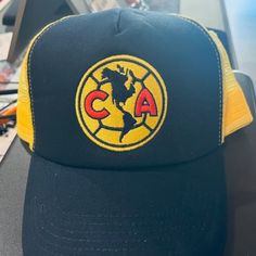 This Is An Outstanding Item For International Soccer Fans, A Brand New With Tags Club America Authentic Liga Mx Team Logo Trucker Hat, One Size Fits All. An Authentic Liga Mx Club America Hat, This Club America Authentic Liga Mx Team Logo Trucker Hat Features The Club America Team Logo Embroidered On The Front, Contrast Mesh Back Trucker Design With A Team Color Snapback Enclosure. If You Have Any Questions Regarding This Brand New With Tags Club America Authentic Liga Mx Team Logo Trucker Hat, Yellow Snapback Trucker Hat With Letter Print, Yellow Letter Print Snapback Trucker Hat, Yellow Sports Hat With Curved Brim, Yellow Sports Trucker Hat With Curved Brim, Yellow Adjustable Trucker Hat With Letter Print, Yellow Letter Print Trucker Hat, Yellow Cap For Sports Events, Yellow Trucker Baseball Cap For Outdoor, Yellow Trucker Hat For Sports