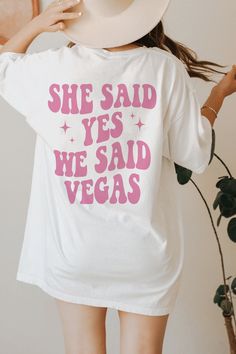 a woman wearing a white t - shirt that says she said yes we said vegas