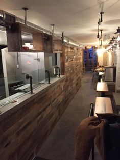 an empty restaurant with wooden counter tops and stainless steel appliances on the wall behind it