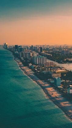 an aerial view of the beach and ocean in miami, with high rise buildings on either side