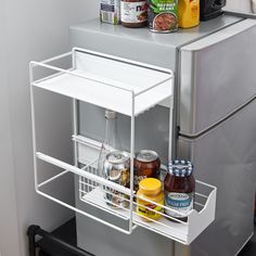 an open refrigerator door with food and condiments on the bottom shelf next to it