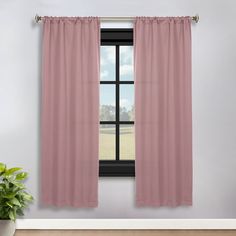 a window with pink curtains and a potted plant