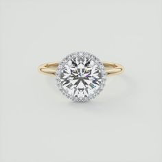 a yellow gold ring with a round brilliant cut diamond surrounded by pave diamonds