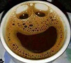 there is a coffee cup with some smiley faces in it