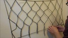 a man is working on a fence that has been made out of barbed wire and nails