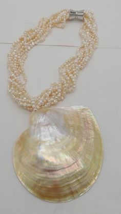 a pearl necklace with a large shell on it