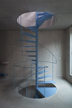 a blue spiral staircase in an empty room