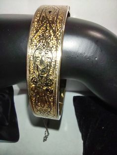 A beautiful vintage 19th-century Victorian taille d'epargne bangle bracelet made by Bliss Bros. The etched floral bangle bracelet is stamped B Co in a large B.  It's 1/20 12K and measures 57mm around the inside and 13 mm wide. The yellow gold-filled bangle has its original Safety chain and a Strong push-in clasp, In beautiful antique condition, the bracelet shows minor wear. Antique Gold Cuff Bracelet For Formal Occasions, Antique Yellow Gold Bangle For Formal Occasions, Heirloom Gold Hinged Bracelets, Heirloom Gold Hinged Bracelet, Victorian Style Yellow Gold Bracelets With Intricate Design, Antique Yellow Gold Bracelets With Intricate Design, Vintage Yellow Gold Engraved Bracelet, Formal Cuff Bracelet With Intricate Design, Vintage Engraved Yellow Gold Bracelet