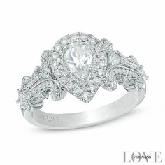 a white gold ring with an oval cut diamond surrounded by smaller round diamonds and pave set shoulders