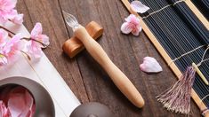 a table topped with lots of pink flowers next to a wooden spoon and knife holder