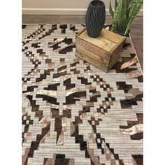 a large rug with an abstract design on the floor next to a potted plant