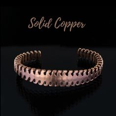 a close up of a metal bracelet on a black background with the words solid copper