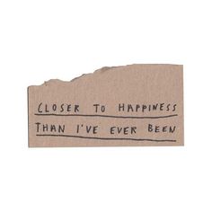 a piece of cardboard with the words closer to happiness than i've ever been