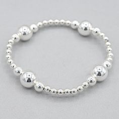 A True statement piece. This Jewel Ya Beaded Lux design instantly elevates your style. Whether you enjoy all sterling beads for a clean crisp look or prefer mixed metal beads you can't go wrong. Every time you add to your wrist you'll be elevating your style. 4mm beads paired with 6 & 10mm sterling silver beads set in four stations. Easy wear and effortless stacking with sturdy stretch cord design. Sizing options to make a comfortable and perfect fit. Every Jewel Ya design comes in our signature Classic Adjustable Stretch Bracelet With Silver Beads, Classic Silver Beads Stretch Bracelet For Everyday, Classic Silver Round Beads Stretch Bracelet, Classic Adjustable Sterling Silver Stretch Bracelet, Classic Adjustable Sterling Silver Bracelet With Spacer Beads, Elegant Silver Bracelets With Large Beads, Elegant Silver Bracelet With Large Beads, Modern Silver Jewelry With 8mm Beads, Classic Sterling Silver Stretch Bracelet