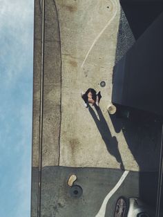 an overhead view of a person laying on the ground next to a parking meter and car